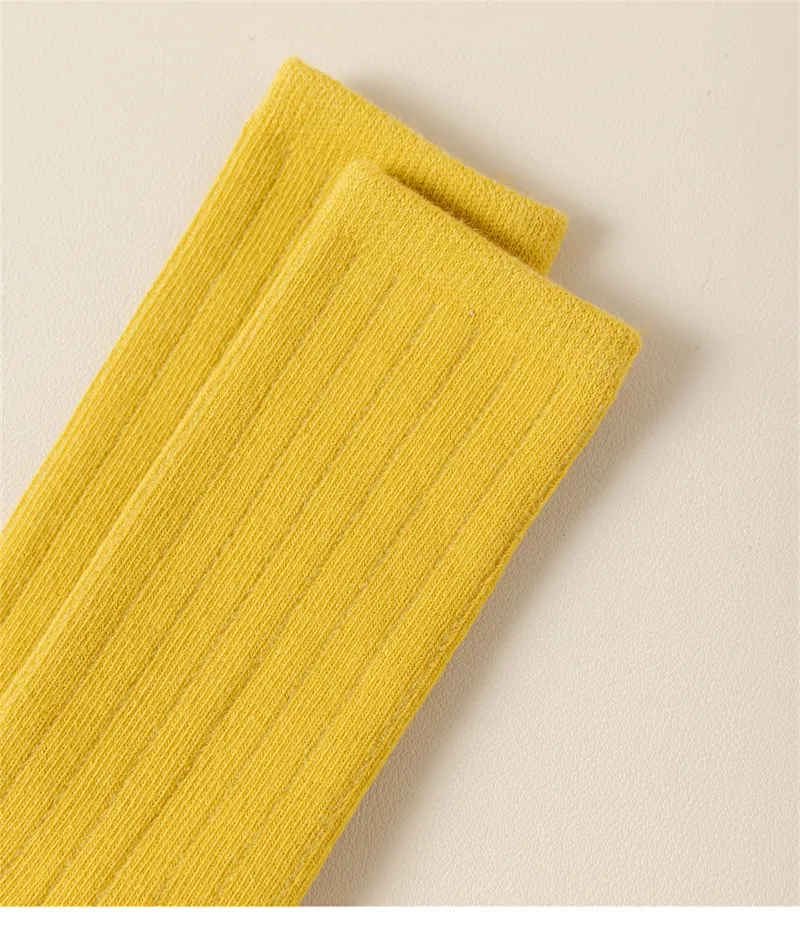 Yellow cotton knit baby socks texture detail showing soft ribbed fabric. Yellow cotton knit baby socks texture detail showing soft ribbed fabric.