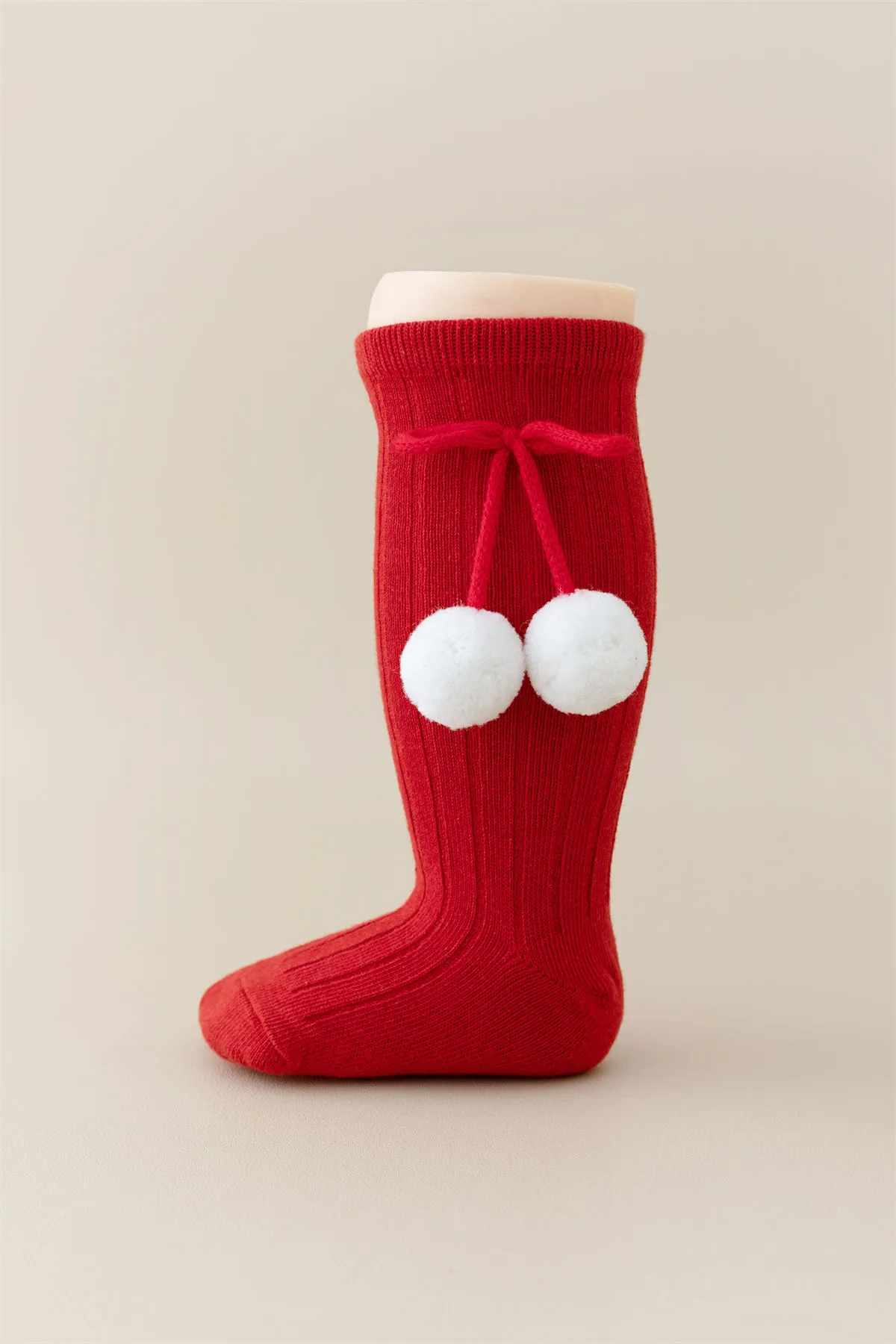Baby girls knee high red socks with white pom pom bow tie, perfect for Christmas wholesale.