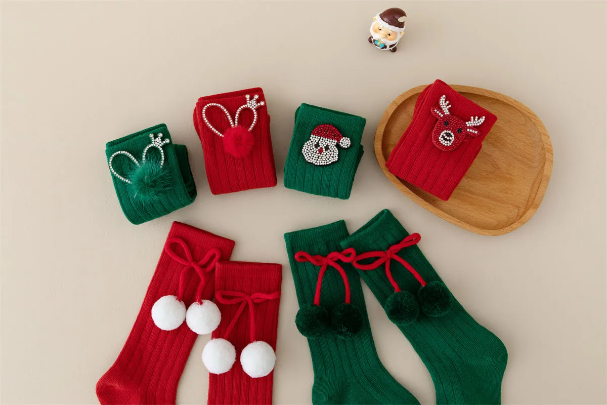 Bulk red and green Xmas knee high socks featuring cute pom poms and rhinestone characters.